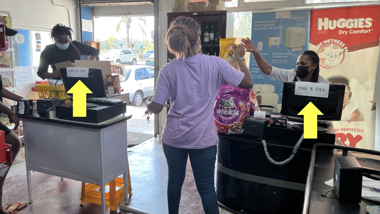 Separate tills for ZWD and USD payments in a Zimbabwean shop